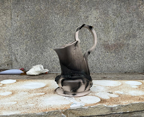Manos de artesano bruñendo una pieza de cerámica para compactar la superficie antes de la cocción de Terra Sigillata.