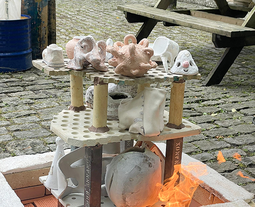 Primer plano de un cuenco de Raku terminado, mostrando los efectos de irisación y las grietas oscuras típicas de esta técnica japonesa.