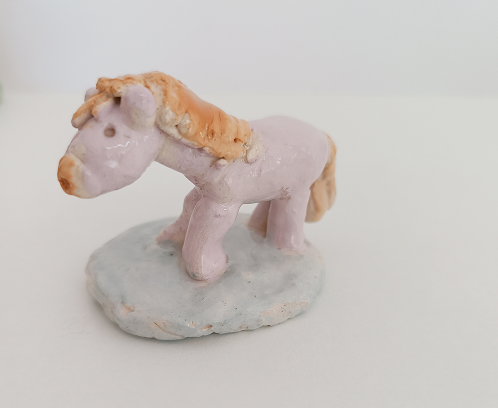 Ambiente de aprendizaje en el taller infantil de cerámica, con niños modelando piezas de barro inspiradas en la historia