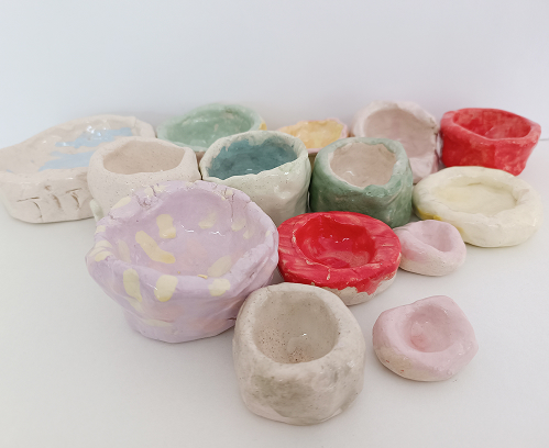 Ambiente de aprendizaje en el taller infantil de cerámica, con niños modelando piezas de barro inspiradas en la historia