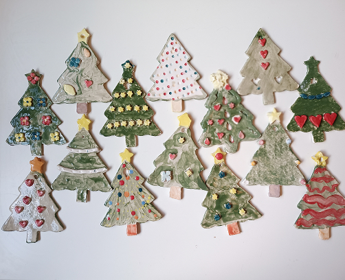 Bosque de árboles de Navidad de cerámica artesanal con diferentes acabados: esmaltes verdes, puntos de colores, estrellas y corazones en relieve.